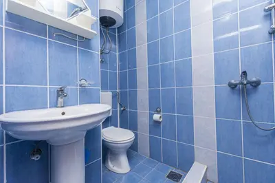 a blue bathroom with a toilet and a sink at Apartments Aleksandar in Ulcinj