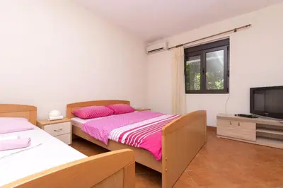 a bedroom with two beds and a flat screen tv at Apartments Aleksandar in Ulcinj