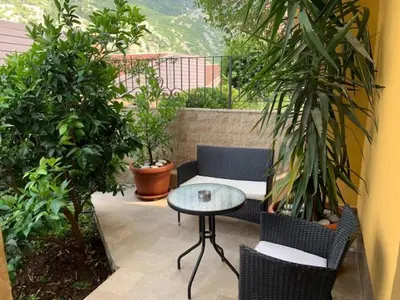 a patio with a table and chairs and plants at Villa Lili in Kotor