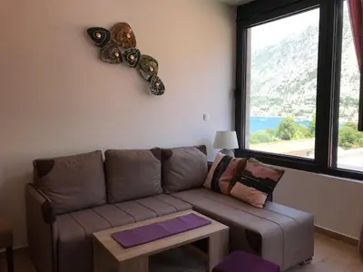 a living room with a couch and a large window at Villa Lili in Kotor