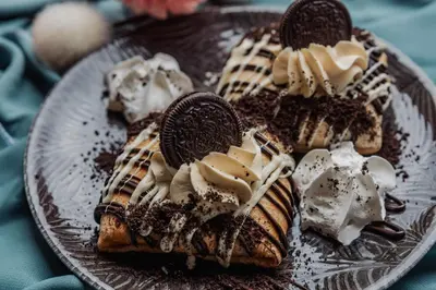 a plate of waffles with cookies and whipped cream at Le Petit Chateau in Bar