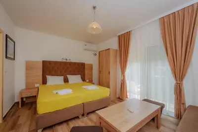 a bedroom with a yellow bed and a couch at Apartments Sole Mar in Sutomore