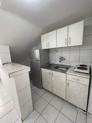a kitchen with white cabinets and a stainless steel refrigerator at Apartments Sole Mar in Sutomore