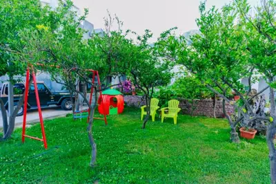 a yard with a swing set in the grass at Apartments Sole Mar in Sutomore