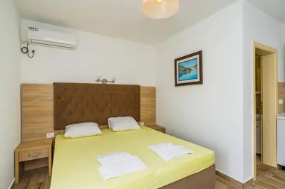 a bedroom with a large yellow bed with two pillows at Apartments Sole Mar in Sutomore