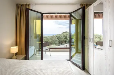 a bedroom with a large glass door leading to a balcony at Adria lux apartmens 2 in Sveti Stefan