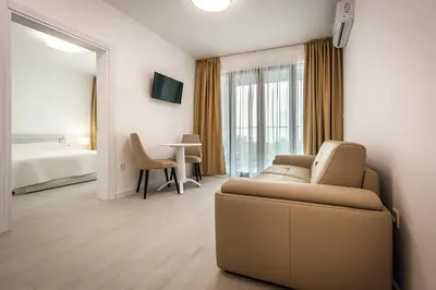 a living room with a couch and a bedroom at Adria lux apartmens 2 in Sveti Stefan