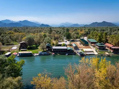 a town on the river with mountains in the background at Apartments Obala in Podgorica