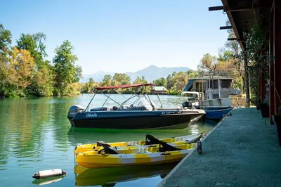 three boats are docked at a dock on a river at Apartments Obala in Podgorica