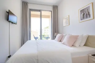 a bedroom with a large white bed with a window at Apart SKY Residence with sea view in DELMAR in Budva