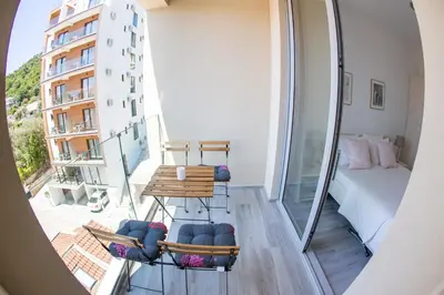 a room with a balcony with a bed and a bedroom at Apart SKY Residence with sea view in DELMAR in Budva