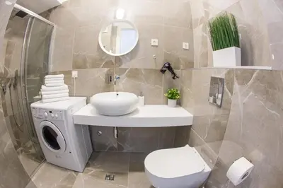 a bathroom with a toilet and a sink and a washing machine at Apart SKY Residence with sea view in DELMAR in Budva