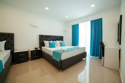 a bedroom with two beds and blue curtains at Hotel Ambiente Ulcinj in Ulcinj