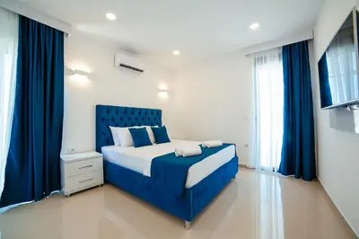 a bedroom with a blue bed with blue curtains at Hotel Ambiente Ulcinj in Ulcinj