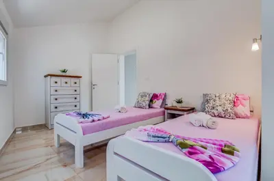 a bedroom with two beds and a dresser at Dolaca Villas in Sutomore