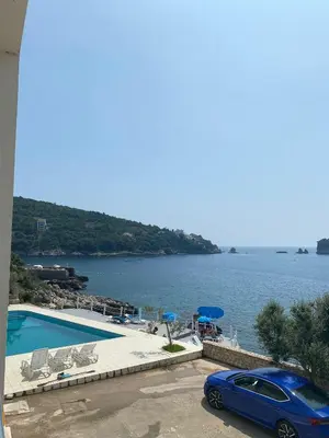 a blue car parked next to a swimming pool at Apartments Harmony in Utjeha