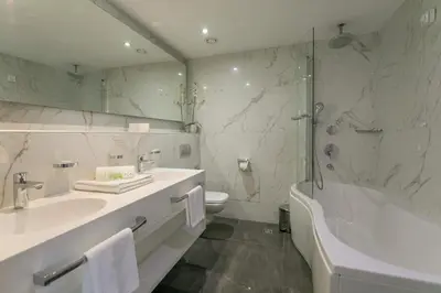 a bathroom with a tub and a sink and a shower at Hotel Aurel in Podgorica