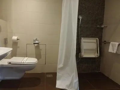 a bathroom with a white toilet and a shower at Hotel Aurel in Podgorica