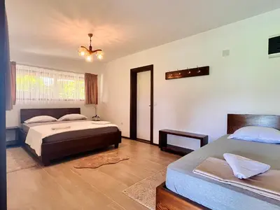 a bedroom with two beds and a chandelier at Balabani Local Stay in Podgorica