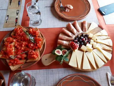 a table topped with plates of cheese and fruit at Balabani Local Stay in Podgorica