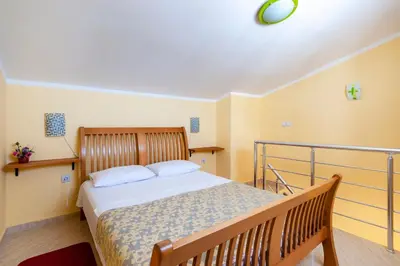 a bedroom with a bed with a wooden rail at Villa Orpheus in Bar