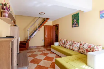 a living room with a couch and a staircase at Villa Orpheus in Bar