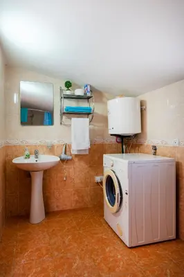 a bathroom with a washing machine and a sink at Villa Orpheus in Bar