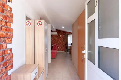 a hallway with a red brick wall and a door at Villa Orpheus in Bar