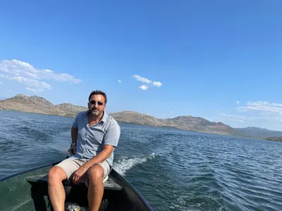 a man sitting in a boat on the water at Skadar lake house Bobija in Podgorica
