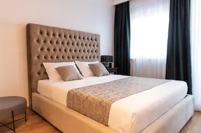 a bedroom with a large bed with a large headboard at Apartments Doclea in Podgorica