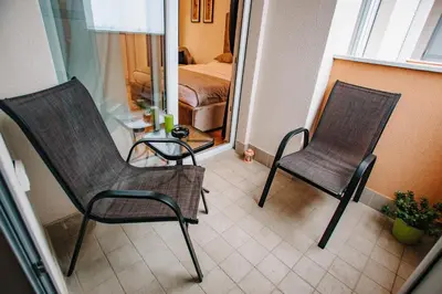 two chairs sitting in a room with a bedroom at Apartments Doclea in Podgorica