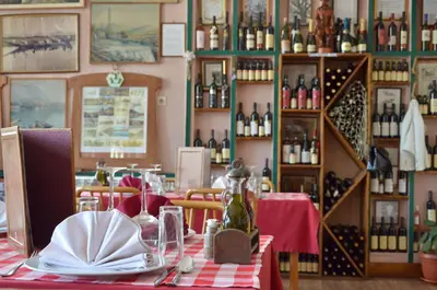 a dining room with a table with a red and white table cloth at Hotel Pelikan in Virpazar
