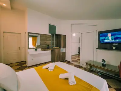 a bedroom with a bed and a tv on the wall at Sun Apartments in Ulcinj