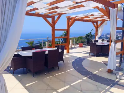 a patio with a table and chairs and a view of the ocean at Sun Apartments in Ulcinj