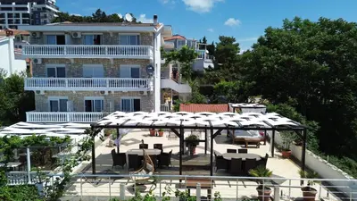 a patio with tables and chairs in front of a building at Sun Apartments in Ulcinj