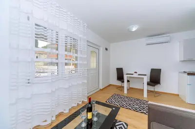 a white room with a table and two chairs at Apartments EcoNature in Virpazar