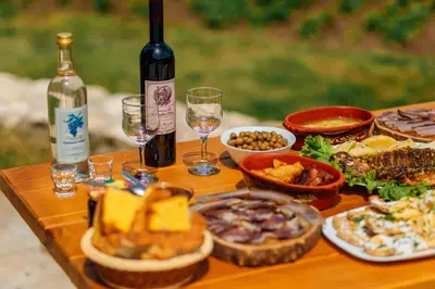 a table with plates of food and glasses of wine at Apartments EcoNature in Virpazar