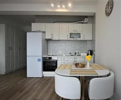 a kitchen with a table and a white refrigerator at Rafailovici Studio Vita in Rafailovici