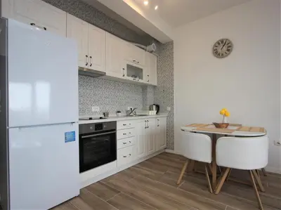 a kitchen with a white refrigerator and a table at Rafailovici Studio Vita in Rafailovici