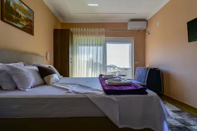 a bedroom with a large bed with a window at Apartments Hillside in Ulcinj