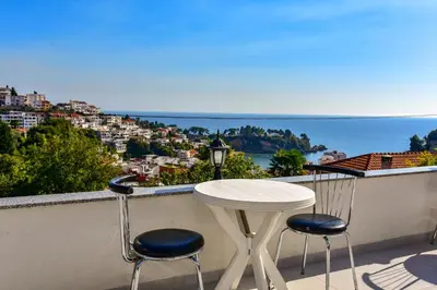 a table and chairs on a balcony with a view of the ocean at Apartments Hillside in Ulcinj