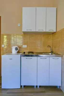 a kitchen with white cabinets and a sink at Apartments Hillside in Ulcinj