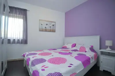 a bedroom with a purple and white bed and a window at Seaside Apartments Petrovac in Petrovac na Moru