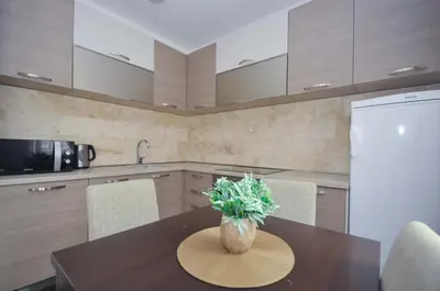 a kitchen with a table with a vase of flowers on it at Seaside Apartments Petrovac in Petrovac na Moru