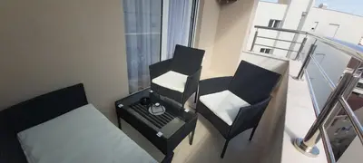 a balcony with two chairs and a bed and a table at Apartment Boki in Budva
