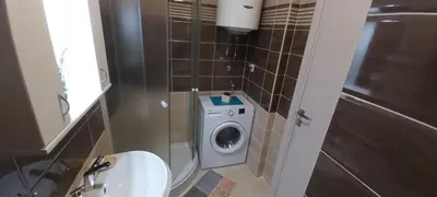 a bathroom with a washing machine and a sink at Apartment Boki in Budva