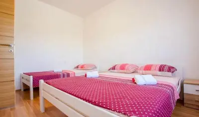two beds in a room with pink and white sheets at Skadar Lake Apartment-Nikola in Podgorica