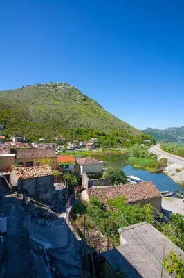 a small village with a river and a mountain at Skadar Lake Apartment-Nikola in Podgorica