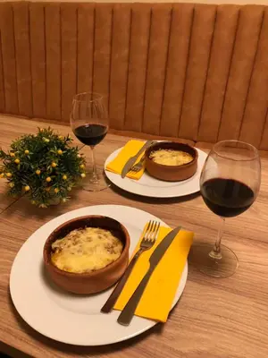 a table with two plates of food and two glasses of wine at Apartments E&S in Ulcinj