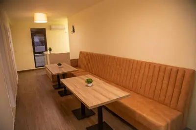 a waiting room with two tables and a couch at Apartments E&S in Ulcinj